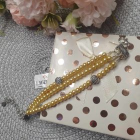   Háromsoros teklagyöngy karkötő, arany színben, rózsa köztessel.