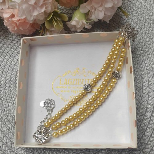 Háromsoros teklagyöngy karkötő, arany színben, rózsa köztessel.