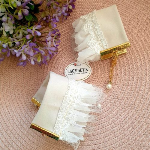 Törtfehér csuklódísz, csipkés, gyöngyös.