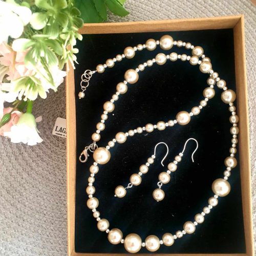 Ezüst színű teklagyöngy nyaklánc-fülbevaló szett.