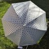 Fehér, fekete pöttyös automata esernyő.