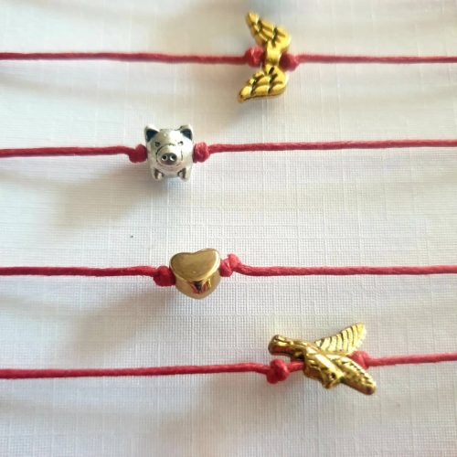 Piros, kabbala zsinórkarkötő fém dísszel.