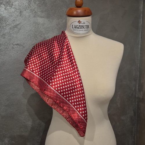 Kék vagy piros, fehér pöttyös szaténkendő.