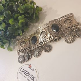 Keleties hatású, érmés fém karkötő.