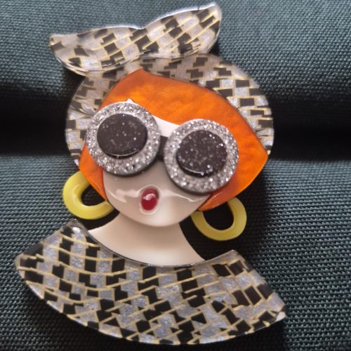 Női arc karakter kitűző vörös hajjal.