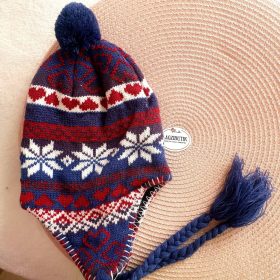   Norvégmintás bélelt gyereksapka fonott, bojtos pántokkal.