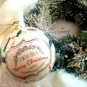   Krémszínű karácsonyfadísz, gömb, függődísz felirattal.