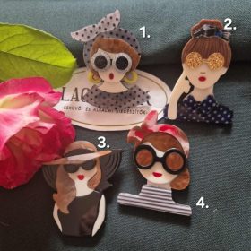 Női arc karakter kitűző barna hajjal.