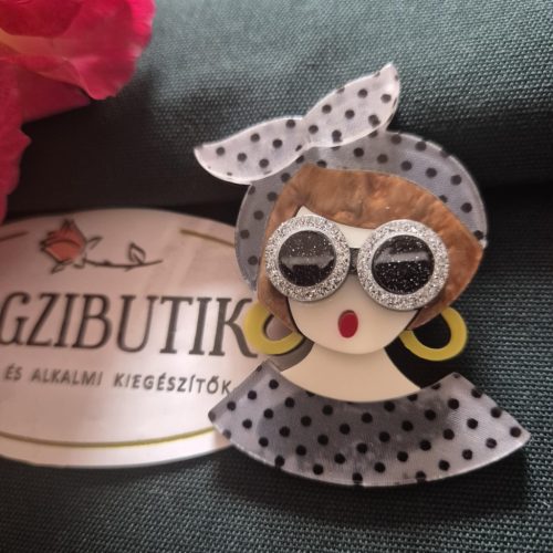 Női arc karakter kitűző barna hajjal.