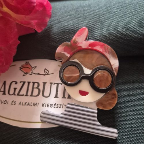 Női arc karakter kitűző barna hajjal.