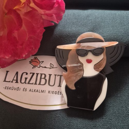 Női arc karakter kitűző barna hajjal.