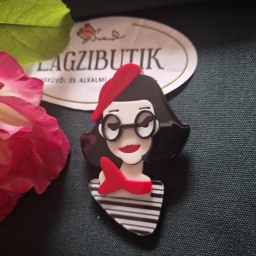 Női arc karakter kitűző fekete hajjal.