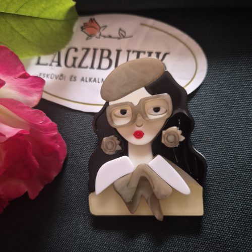 Női arc karakter kitűző fekete hajjal.