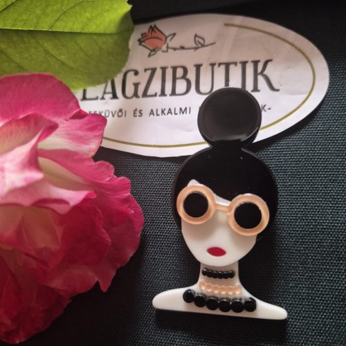 Női arc karakter kitűző fekete hajjal.