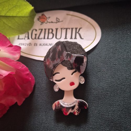 Női arc karakter kitűző fekete hajjal.