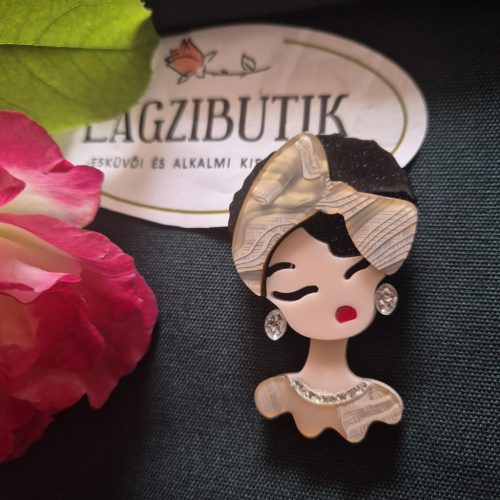 Női arc karakter kitűző fekete hajjal.