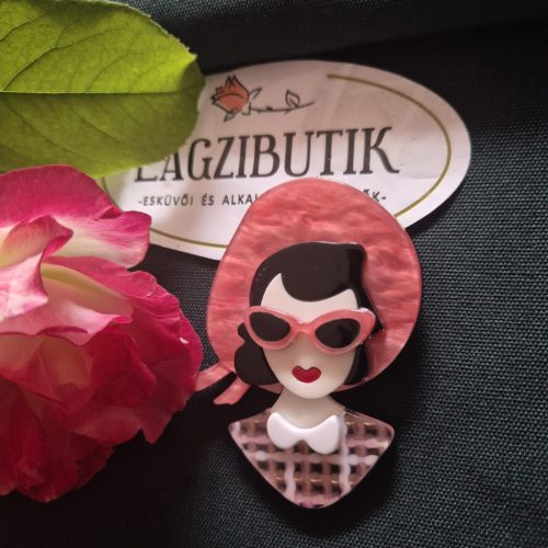 Női arc karakter kitűző fekete hajjal.