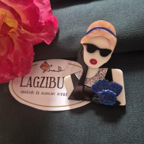 Női arc kitűző szőke hajjal.