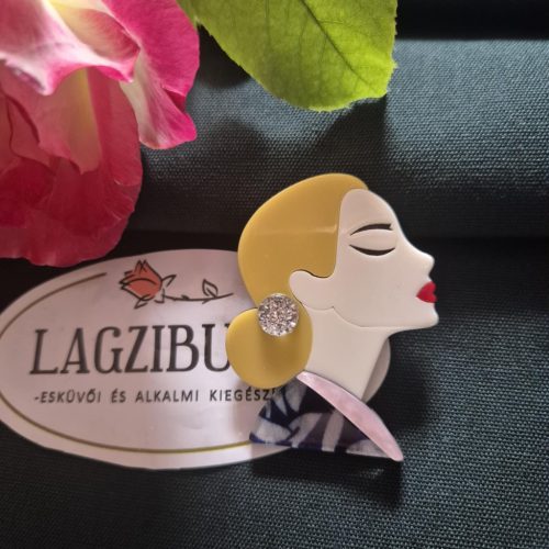 Női arc kitűző szőke hajjal.