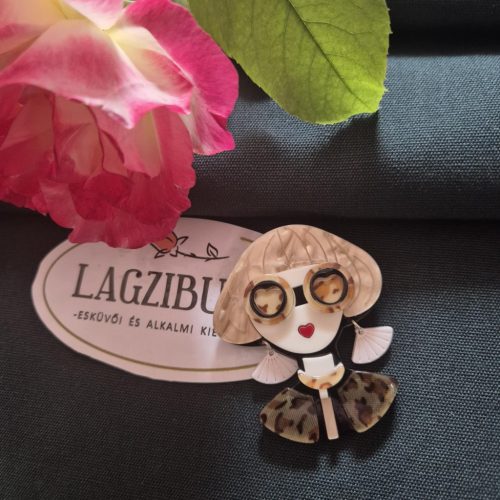 Női arc kitűző szőke hajjal.