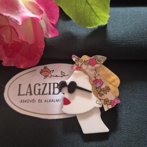 Női arc kitűző szőke hajjal.