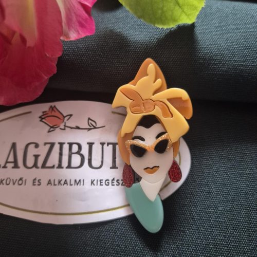 Női arc kitűző szőke hajjal.