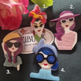 Női arc karakter kitűző, színes hajjal.