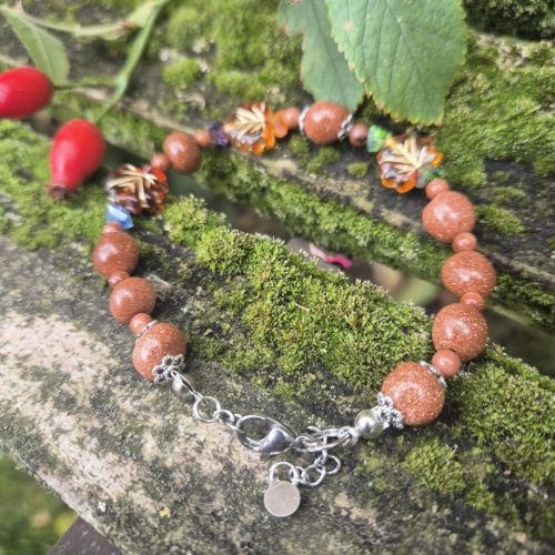 Őszi, barnás színű leveles karkötő kristályokkal.