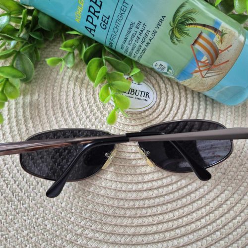 Ovális lencséjű fém keretes napszemüveg.