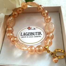   Patkó medálos bézs színű aura gyöngykarkötő, ovális gyöngyszemekkel.