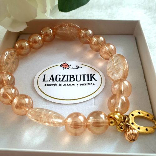 Patkó medálos bézs színű aura gyöngykarkötő, ovális gyöngyszemekkel.