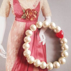   Teklagyöngy törtfehér karkötő, tűzpiros üveg szívecskével.