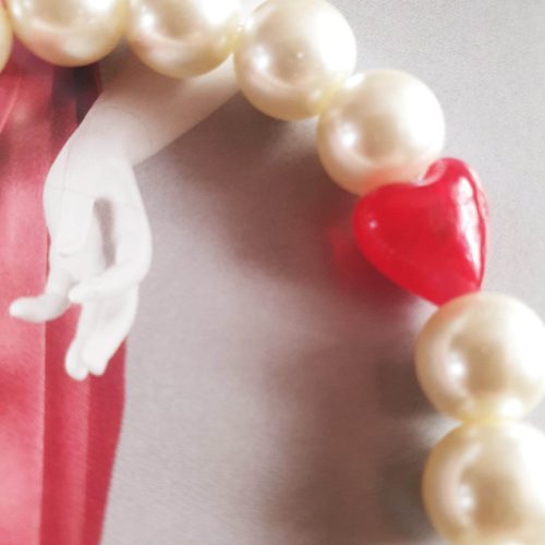 Teklagyöngy törtfehér karkötő, tűzpiros üveg szívecskével.