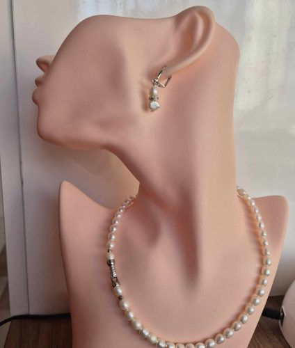 Törtfehér, rizsszemű édesvízi igazgyöngy-szett, cirkónia köves ékszerkapoccsal.