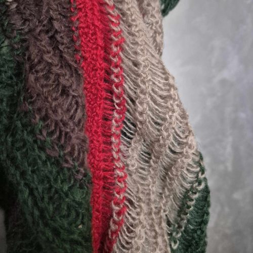 Zöldes színű kötött, gumis sál.