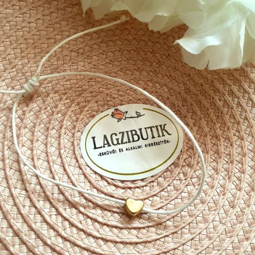 Fehér zsinórkarkötő, apró arany szívecskével.